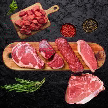 Bœuf halal cru : steaks et morceaux variés sur planche avec épices et herbes fraîches.