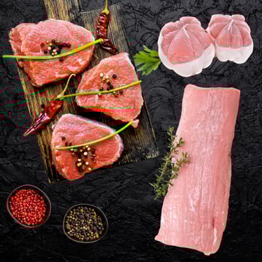 Veau halal cru : pavés et morceau entier assaisonnés avec herbes et épices sur planche.