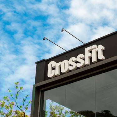 Placa CrossFit na fachada do Morro das Pedras em Florianópolis, box localizado no sul da Ilha, céu azul ao fundo.