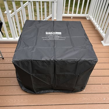 Fully assembled square firepit table under its protective black cover in Methuen, MA.