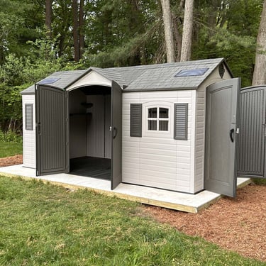A beige Lifetime resin shed with brown doors, roof and shutters. 8 feet by 15 feet with front and side entry double doors.