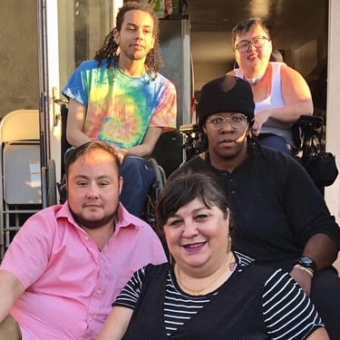 Photo of Stacey with members of DJCC sitting on stairs.