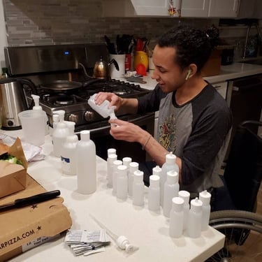 Photo. of Stacey's friend Charlie making home made wellness kits in the kitchen.