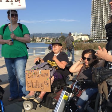 Photo of Stacey with friends at a protest with a sign saying "cops are killing us"