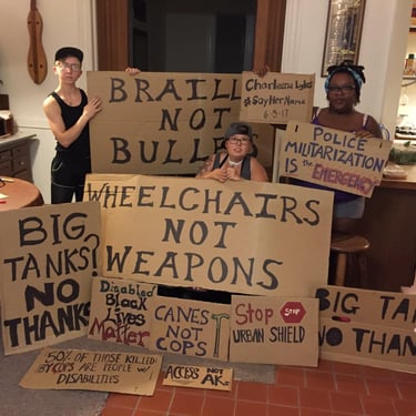 Photo of Stacey with Friends displaying posters they made in protest of Urban Shield and supporting BLM.
