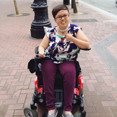 Photo of young Stacey with cropped hair on sidewalk.