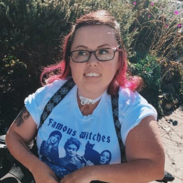 Photo in vintage style, Stacey with pink hair and shirt "Famous Witches" looking away from camera. 