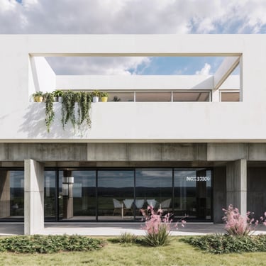 Una galería en planta baja, en homrigón visto y el contraste con una terraza en planta alta en blanco puro. casa minimalista