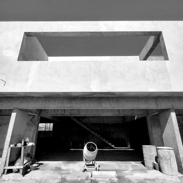 una casa con un gran ventanal en planta baja, hormigón visto y una terraza en planta alta. diseñada por arquitectura con sen