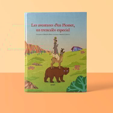 Catalan children's book cover featuring animals stacked on a bear in a mountain landscape.