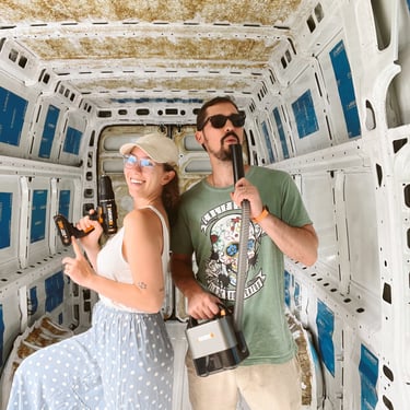 a man and woman standing in a van with power tools