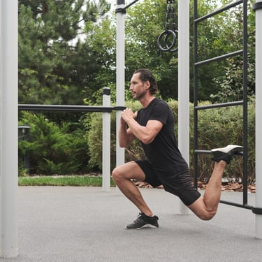 Homme réalisant une fente sur un espalier suédois Kenguru Pro en extérieur.