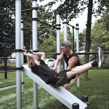 Enfant s’entraînant sur un équipement Kenguru Pro Kids Workout avec l’aide d’un coach.