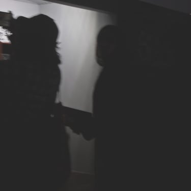 Siluetas oscuras y desenfocadas en un entorno de sombras profundas.