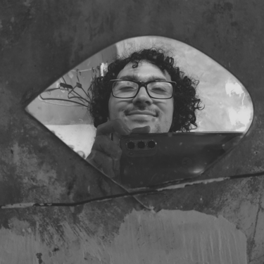 Selfie sonriente en un espejo roto con textura, en blanco y negro.