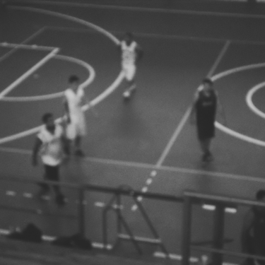 Imagen en blanco y negro desenfocada de jugadores en una cancha.