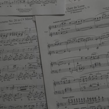 Partituras de piano: Nocturno de Chopin y Claro de Luna de Debussy.
