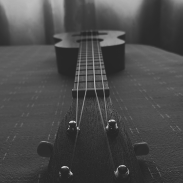 Perspectiva desde el clavijero de un ukelele en blanco y negro.