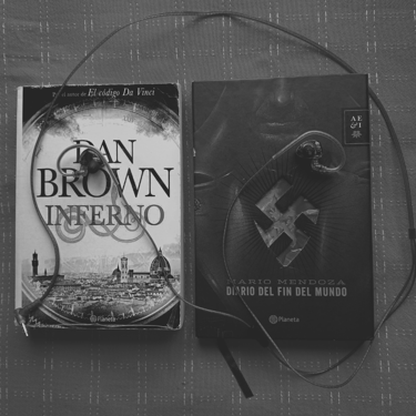 Libros "Inferno" y "Diario del fin del mundo" con audífonos, en blanco y negro.