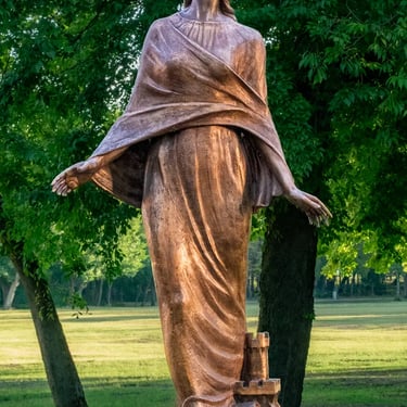 Entire statue of Saint Barbara displaying her full figure, protective hands, and crown as sculpted by Mihály Dabóczi.