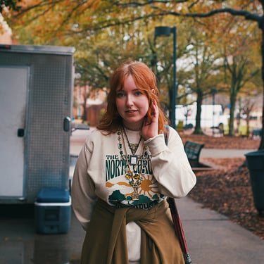Young redheaded college woman smiling at camera.