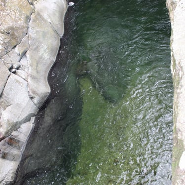 alt="Piscina natural rodeada de piedras y vegetación en la Sierra Nevada de Santa Marta, Dibulla, palomino"