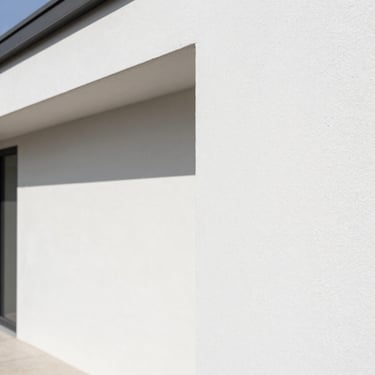Crisp painted edge of a modern residential wall, bright natural daylight, clean high-contrast tones, 35mm