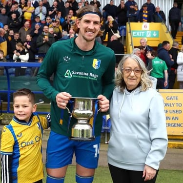 Aden presented with the Trophy on the pitch by Josette Higgins SSA Away Travel Co-Ordinator and Junior Member Lyle Higgins