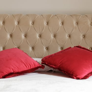 Dettaglio della testiera imbottita e dei cuscini rossi della Camera Tripla Deluxe con balcone a Verona, stile elegante e mode