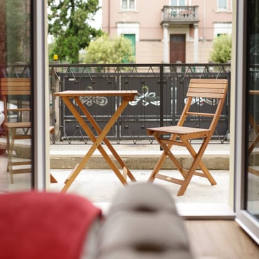 Balcone privato della Camera Tripla Deluxe con tavolo e sedie.