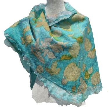Handmade turquoise nuno felted wool scarf with white floral leaf patterns and ruffled edges.