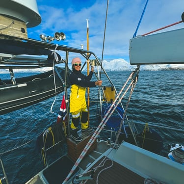 a woman in yellow on a sailing boat adventure in Norway | Jolly Good Times Sailing