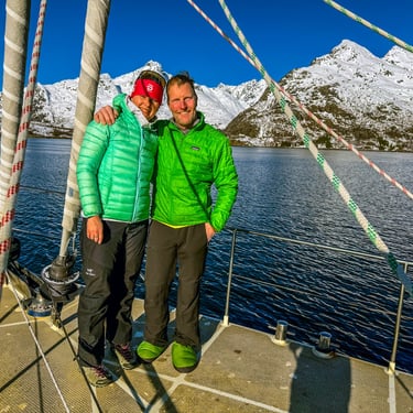 a couple standing on a sailing yacht in a ski and sail advenure in Norway | Jolly Good Times Sailing