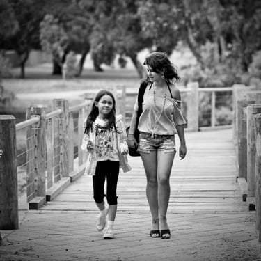 Young woman and child waling over a wooden bridge