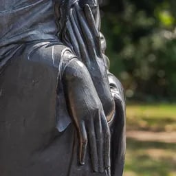 Close up on the hand of the Buddha statue.
