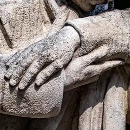 Close‑up on the hand of the doctor and a caregiver.