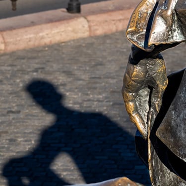 Close-up of Attila József’s other hand with cobblestones behind, evoking hardship and struggle.