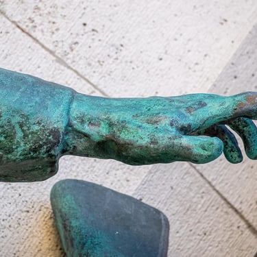 Another student’s bronze hand reaching forward in the ELTE heroic memorial.