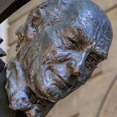 Portrait view of the Solti statue’s head from below, emphasizing presence and stature.