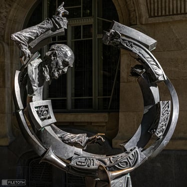 Circular upper statue of Solti, showing head and both hands in a dynamic pose.