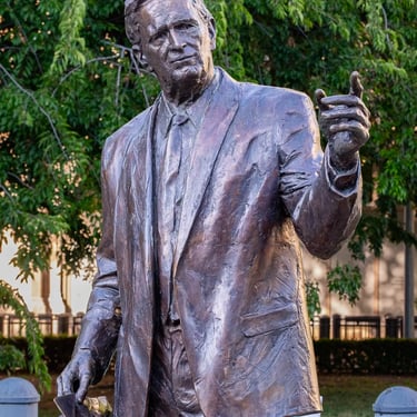 Upper body, head, and pointing hand of the statue, embodying calm statesmanship.