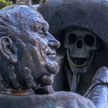 The faces of Géza Hofi and a skeleton are visible in the statue, blending comedy with mortality.