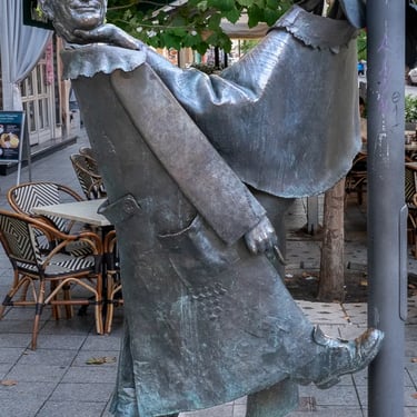 Full view of the Géza Hofi statue by Géza Stremeny, commemorating the influential humorist.