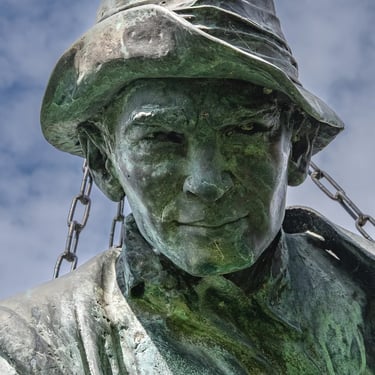Portrait of Imre Soós statue, face turned toward viewer with direct, open expression.