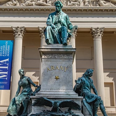 Full view of the János Arany monument with the Hungarian National Museum behind.