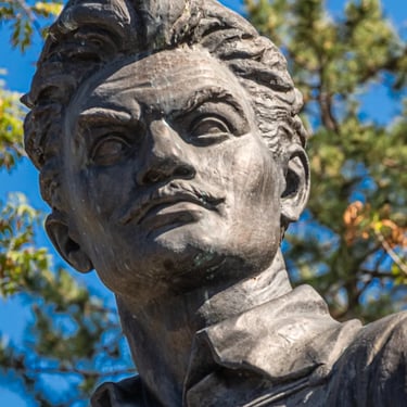 Head of a person seen from behind, gazing forward towards the Kossuth statue.
