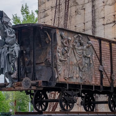 Side view of deported figures grouped on the train wagon, stressing shared fate.