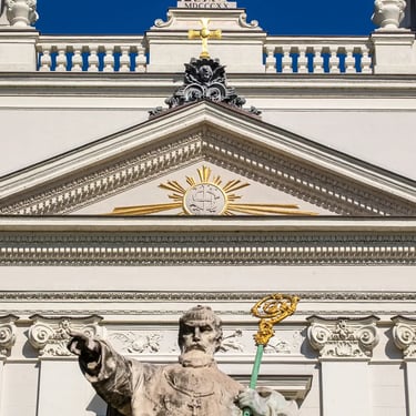 Upper body of the Péter Pázmány statue with Saint Joseph Church visible in the background.