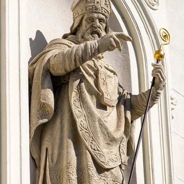 Statue of Saint Gellért positioned on the right facade of the church, dressed in ecclesiastical attire.
