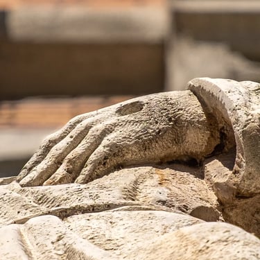 Close-up of his other stigmata-marked hand resting along the wrist in humility.